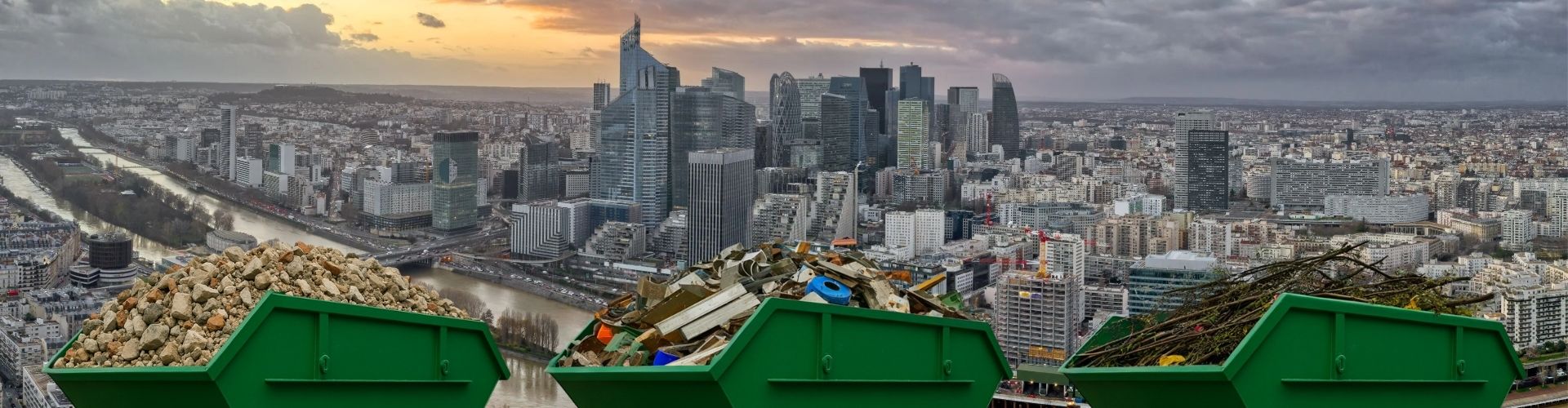 Bennes vertes avec gravats, déchets mélangés et végétaux devant une vue aérienne urbaine.